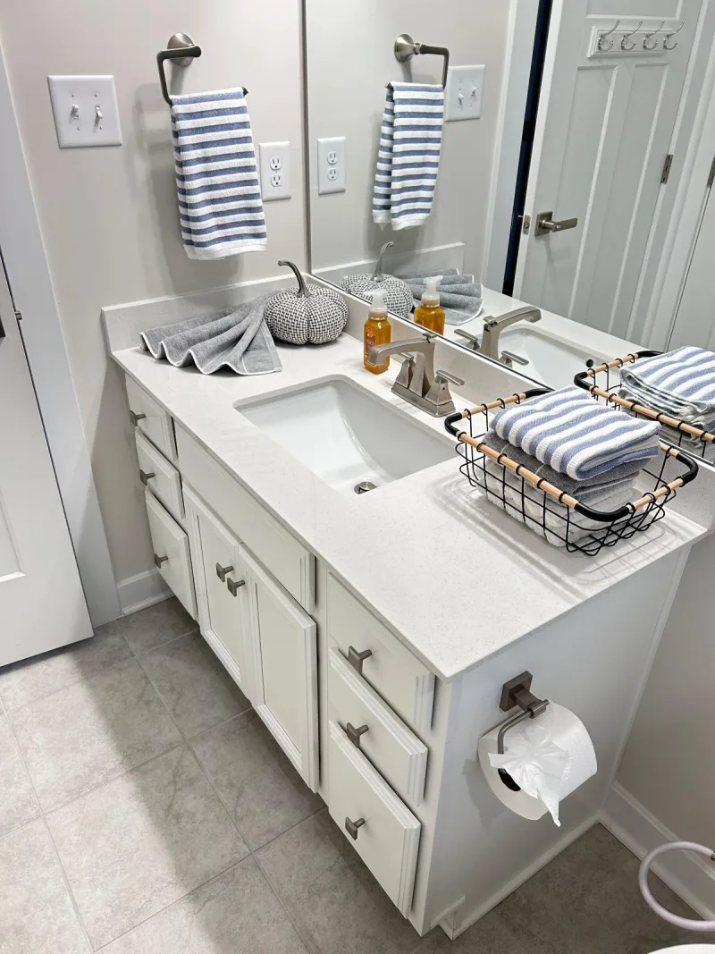 Clean white bathroom vanity with folded striped towels