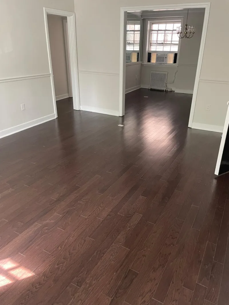 Clean dark hardwood floors in an empty home with white trim